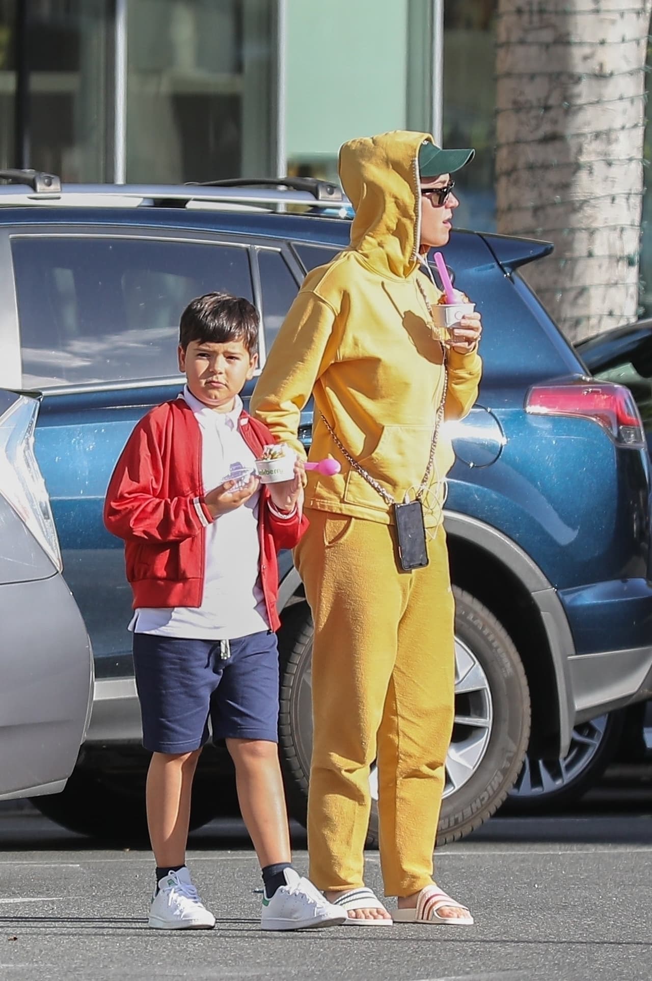 Perry lucía un conjunto deportivo amarillo con una gorra verde.