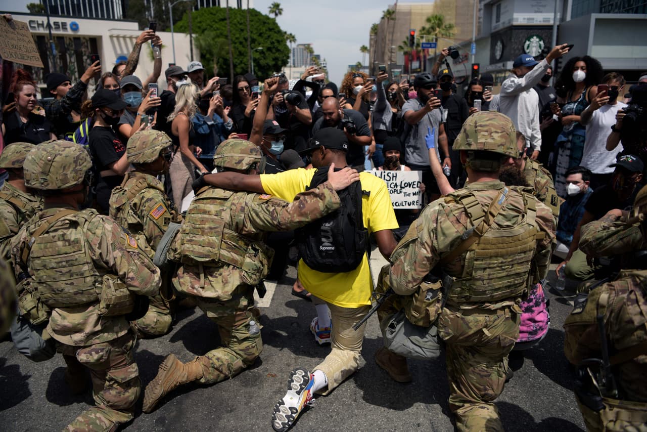 <b>Miembros de la Guardia Nacional se solidarizan. </b>Un grupo de manifestantes y militares se arrodillan para honrar a George Floyd en Los Ángeles, California, el 2 de junio.