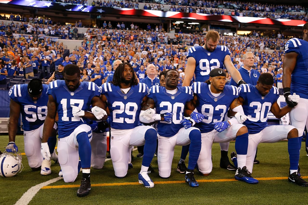 Los Indianapolis Colts, unidos, de pie y arrodillados durante el himno en el Lucas Oil Stadium.