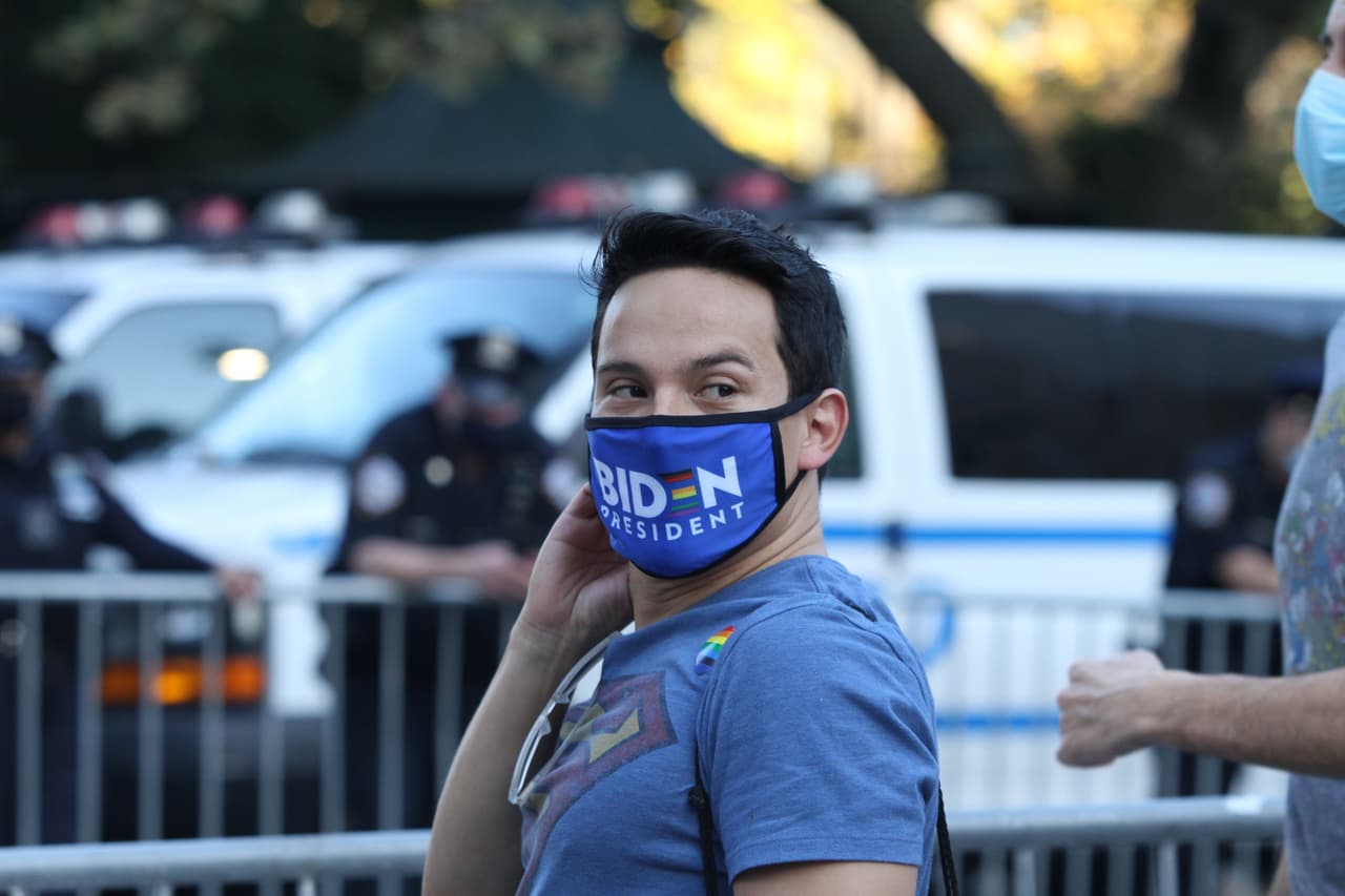 Neoyorquino celebra con su marcarilla con el emblema de Biden en Columbus Circle.