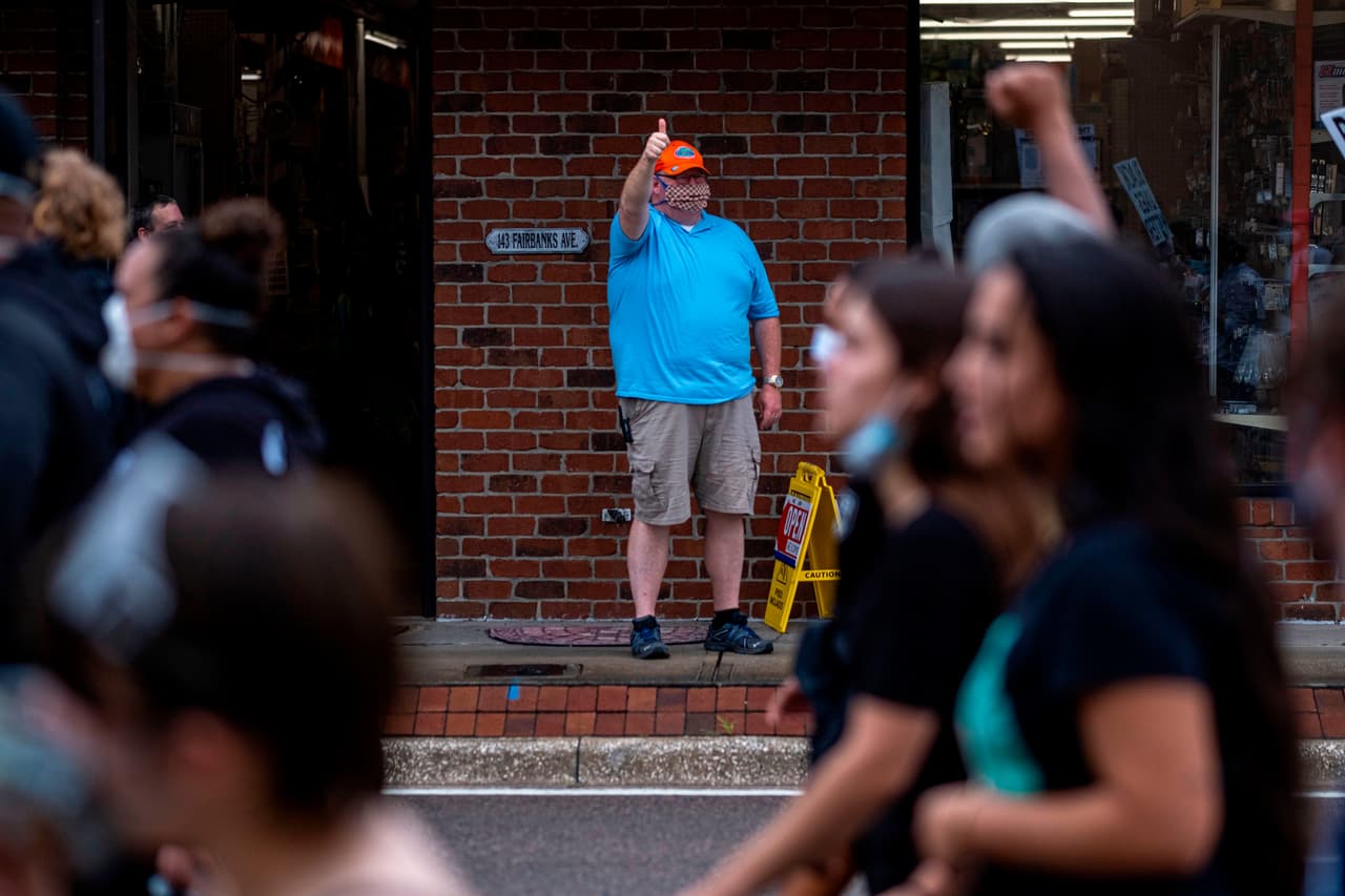 Un transeúnte hace un gesto de apoyo a los manifestantes en Winter Park, Florida.