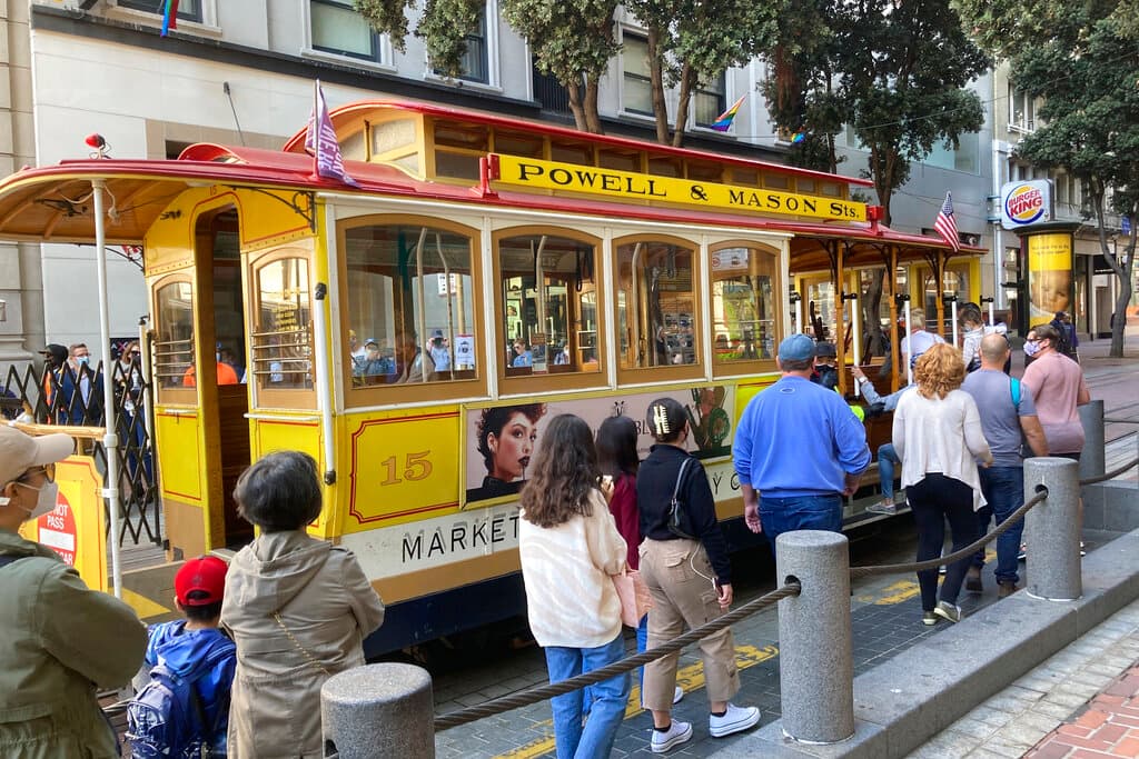 Personas hacen fila para abordar un teleférico en la plaza de cambio de Powell Street en San Francisco, el 2 de agosto de 2021.