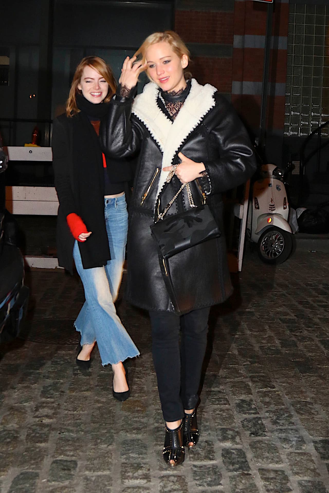 Emma con unos jeans acampanados y también abrigo negro.