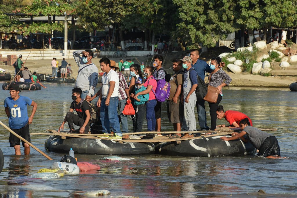 People cross the Suchiate River on a raft from Guatemala to Ciudad Hidalgo, Mexico on January 18, 2021, as a new migrant caravan, mostly of Hondurans heading to the US is expected to arrive.