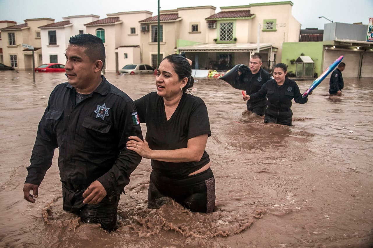Oficiales de la policía de Culiacán han ayudado a algunos residentes a salir de sus hogares inundados.