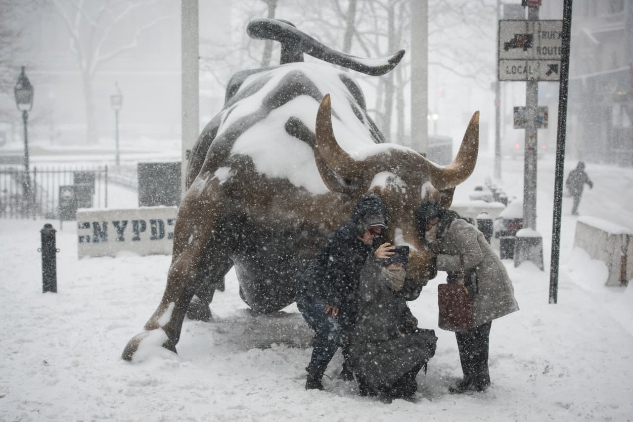 Algunos transeúntes se toman fotografías bajo la nevada en la ciudad de Nueva York.