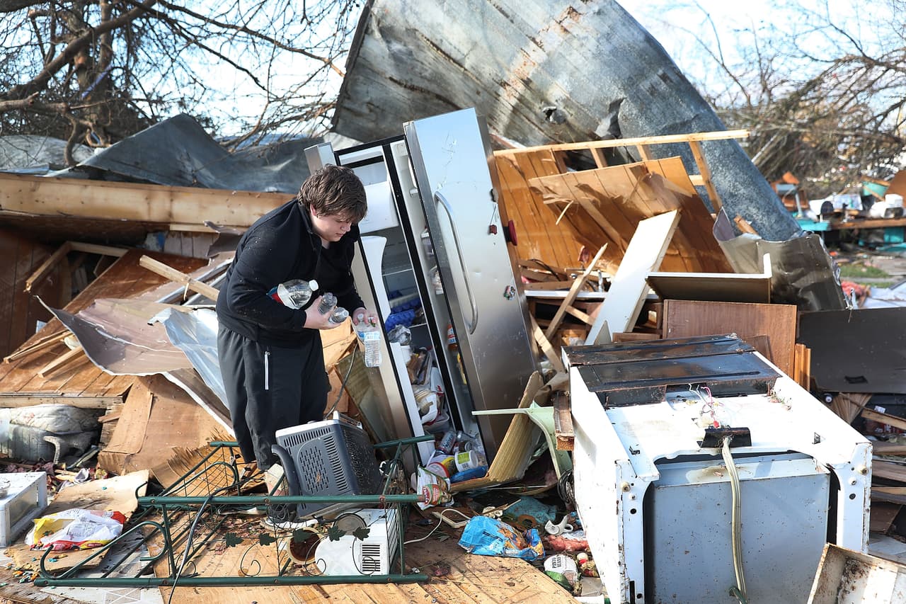Gavin Conklin, de 17 años, recoge botellas de agua de la nevera de un vecino luego de que el huracán Michael destruyera su vivienda en Panama City.