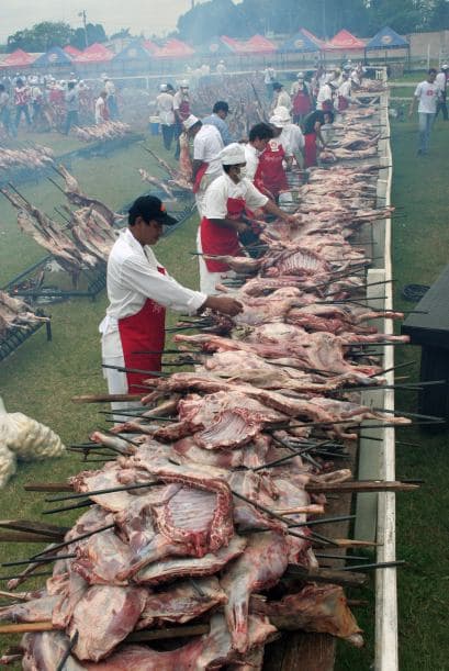 Voluntarios de control de la carne durante un asado solidario denominado "Todo bicho Que Camina va al asador" (Cada criatura que camina va a la barbacoa), para las mujeres víctimas de malos tratos y los niños que sufren de leucemia el 26 de octubre de 2008 en la premisa de Mariano rural Roque Alonso, a cerca de Asunción.