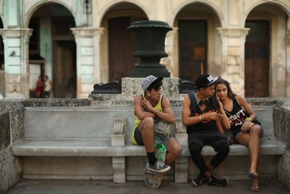 Tres adolescentes ven pasear a los turistas a lo largo del famoso Paseo del Prado, en el barrio de La Habana Vieja.
