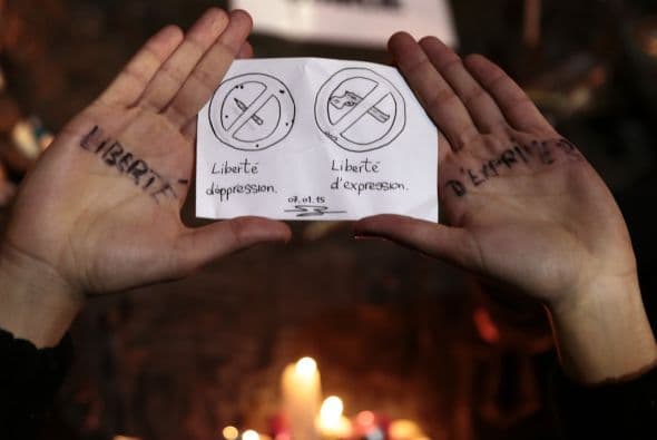 Un participante en la vigilia reclama por la libertad de expresión.