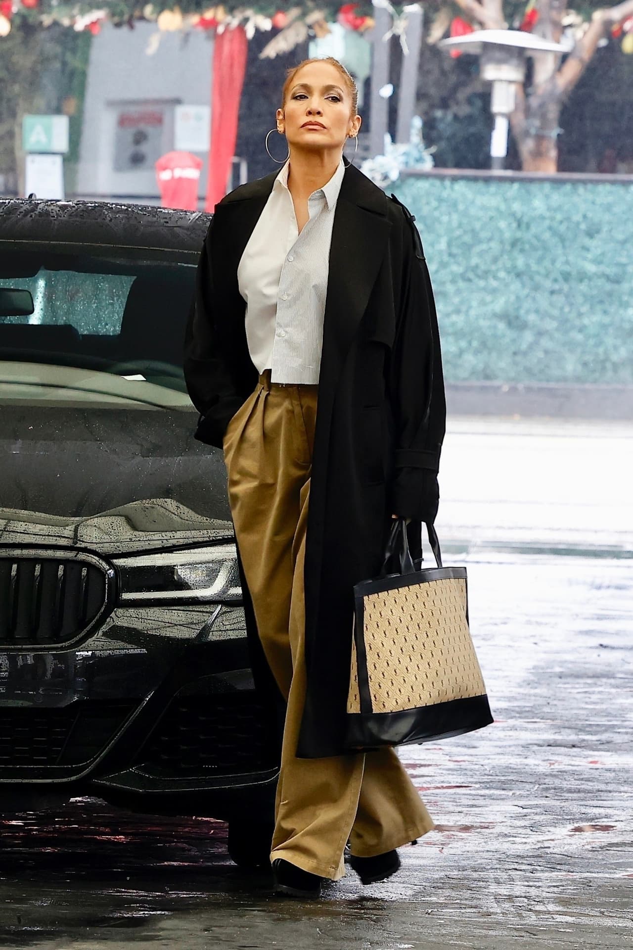 Traía un atuendo para el frío clima que reinó ese día con una elegante gabardina negra sobre una blusa blanca abotonada y pantalones anchos color canela.
<br>