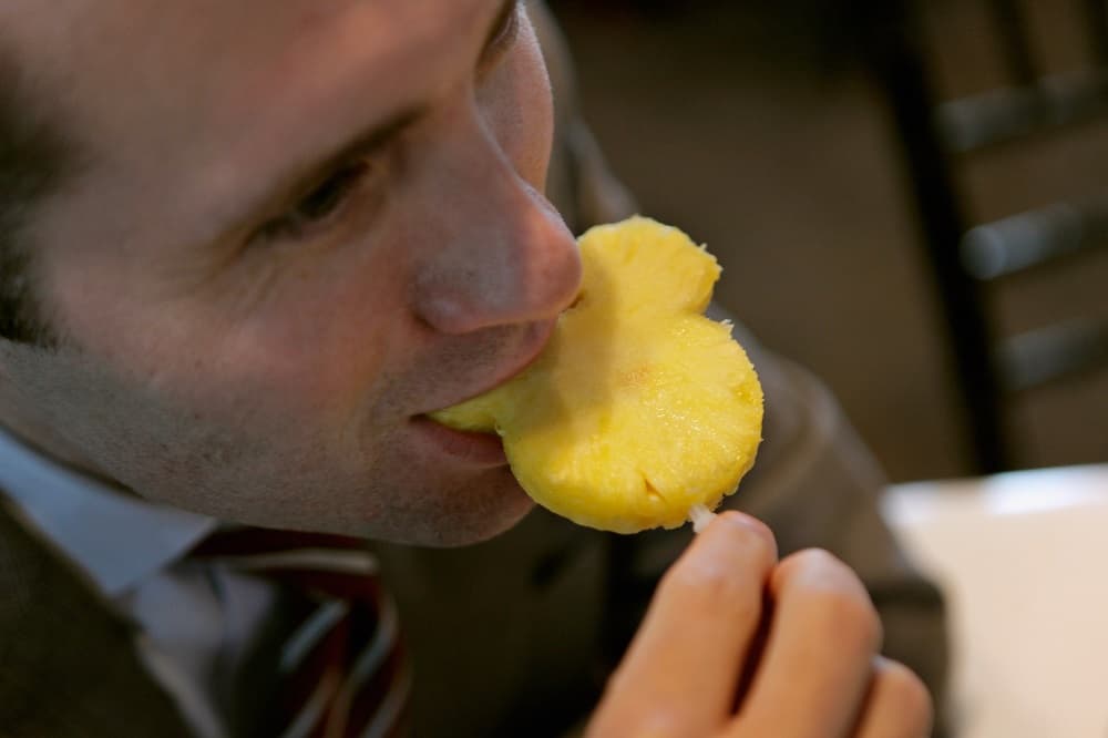 WASHINGTON, DC - JUNE 05: A guest bites into a Mickey Mouse shaped piece of pineapple during an event introducing The Walt Disney Companys new "Magic of Healty Living" program at the Newseum June 5, 2012 in Washington, DC. As part of the new healthy eating initiative, all products advertised on Disney's child-focused television channels, radio stations and Web sites must adhear to a new set of strict nutritional standards. Addionally, Disney-licensed products that meet criteria for limited calories, saturated fat, sodium and sugar can display a logo - Mickey Mouse ears and a check mark - on their packaging. (Photo by Chip Somodevilla/Getty Images)