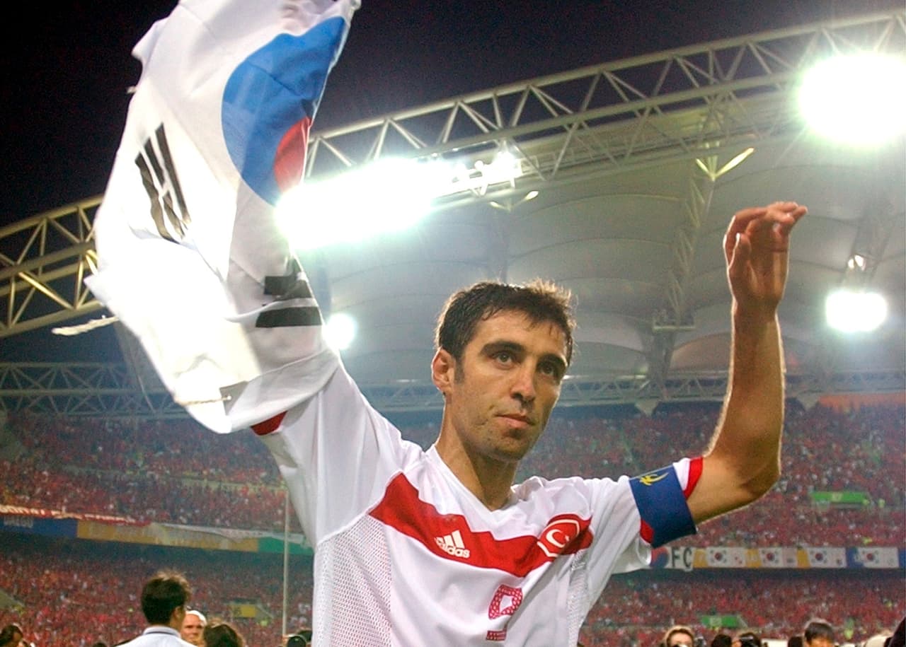 En esta foto de archivo del sábado 29 de junio de 2002, el turco Hakan Sukur sostiene una bandera surcoreana al final del partido de futbol por el tercer puesto de la Copa Mundial de 2002 entre Corea del Sur y Turquía, en el estadio de la Copa Mundial de Daegu, Corea del Sur.