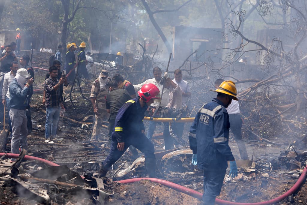 Bomberos trabajan en el lugar donde se estrelló un avión en la ciudad de Ahmedabad, en el noroeste de India, en el estado de Gujarat, el jueves 12 de junio de 2025.