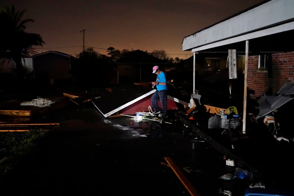 Kathy Pechon camina junto al techo de su cobertizo destruido después de que un tornado arrasara la zona en Arabi.