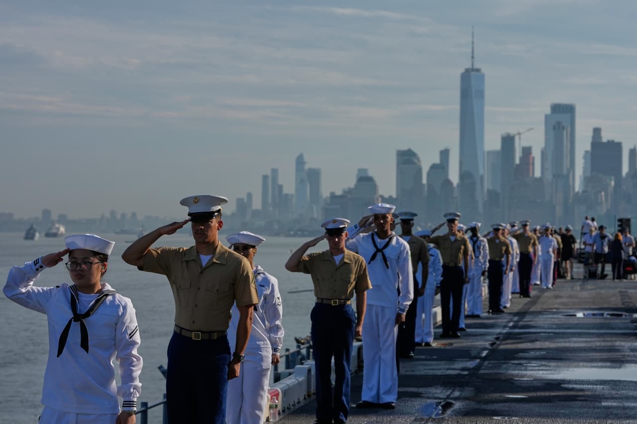 Personal militar saluda desde la cubierta de vuelo del USS Kearsarge (LHD-3) en el puerto de Nueva York durante la Revista Naval Internacional, previa a Sail250, una concentración de grandes veleros y buques militares que conmemoran el 250 aniversario de Estados Unidos, el sábado 4 de julio de 2026, en Nueva York.