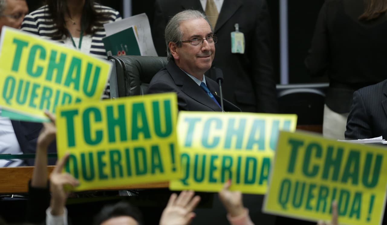 El presidente de la Cámara de Representantes, Eduardo Cunha, encabeza el debate sobre el procedimiento de juicio político contra la presidenta Dilma Rousseff, mientras otros legisladores sostienen letreros que dicen en portugués “Adios querida” en Brasilia, Brasil, el sábado 16 de abril de 2016. Roussef está acusada de violar la ley fiscal para granjearse apoyo público en momentos en que la economía del país está en crisis. Si Rousseff es sometida a juicio político, Cunha sería el tercero en la línea de sucesión para sustituirla después del vicepresidente Michel Temer. Cunha está acusado de lavado de dinero y otros delitos en el escándalo de corrupción de Petrobras. (AP Foto/Eraldo Peres)