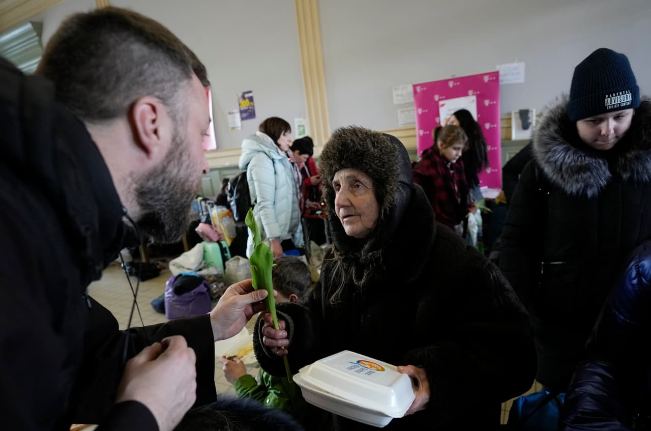 Un sacerdote polaco entrega un tulipán a una mujer que llegó de Ucrania, en el
<b>Día Internacional de la Mujer de 2022, </b>en Przemysl, Polonia. Muchas de ellas han dejado a sus hijos, hermanos, esposos y padres detrás. Un decreto del gobierno ucraniano prohíbe a los hombres entre 18 y 60 años dejar el país para hacer frente al avance de las tropas rusas.
