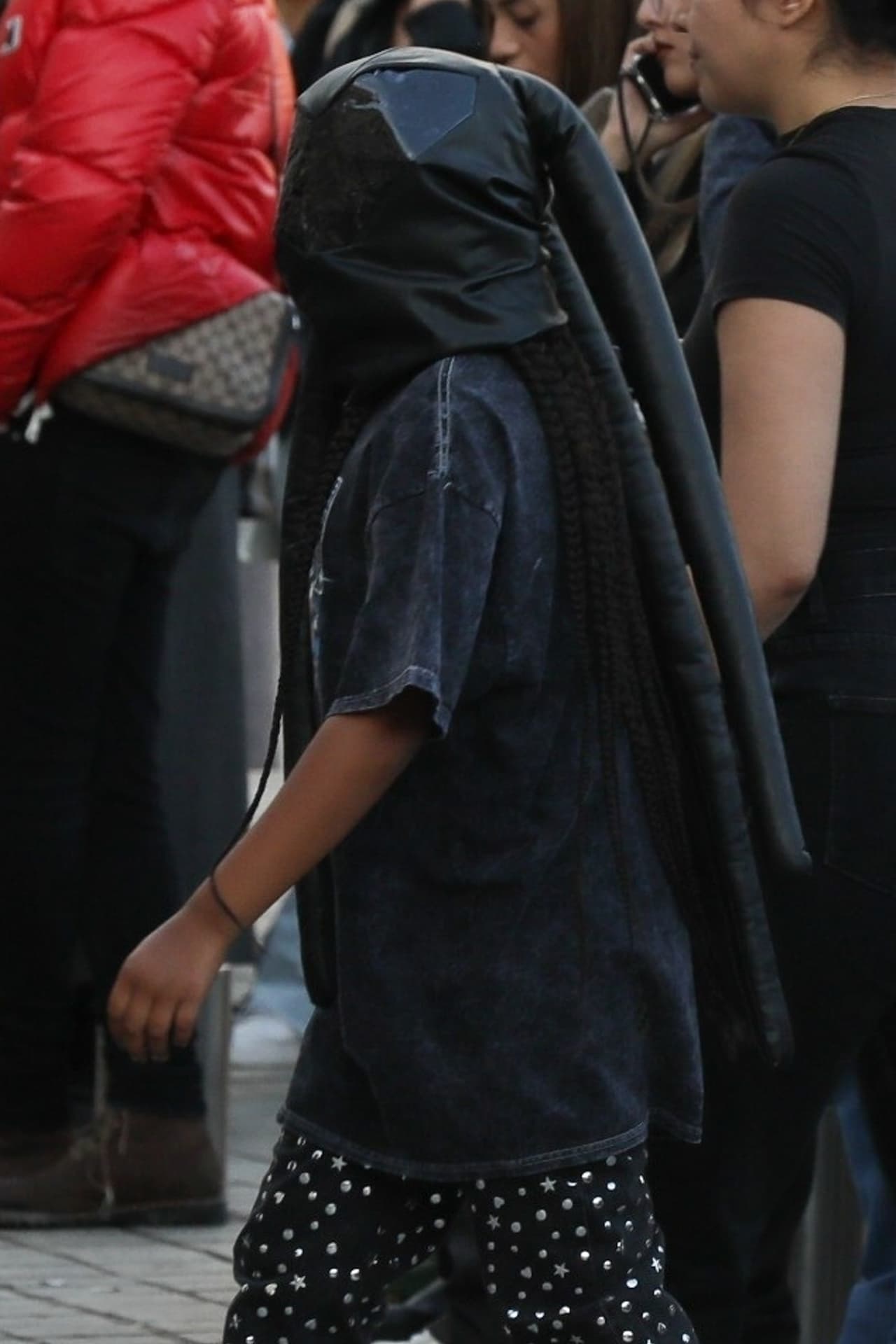 La niña vestía de negro y cubría su rostro como lo han hecho sus famosos padres.
<br>