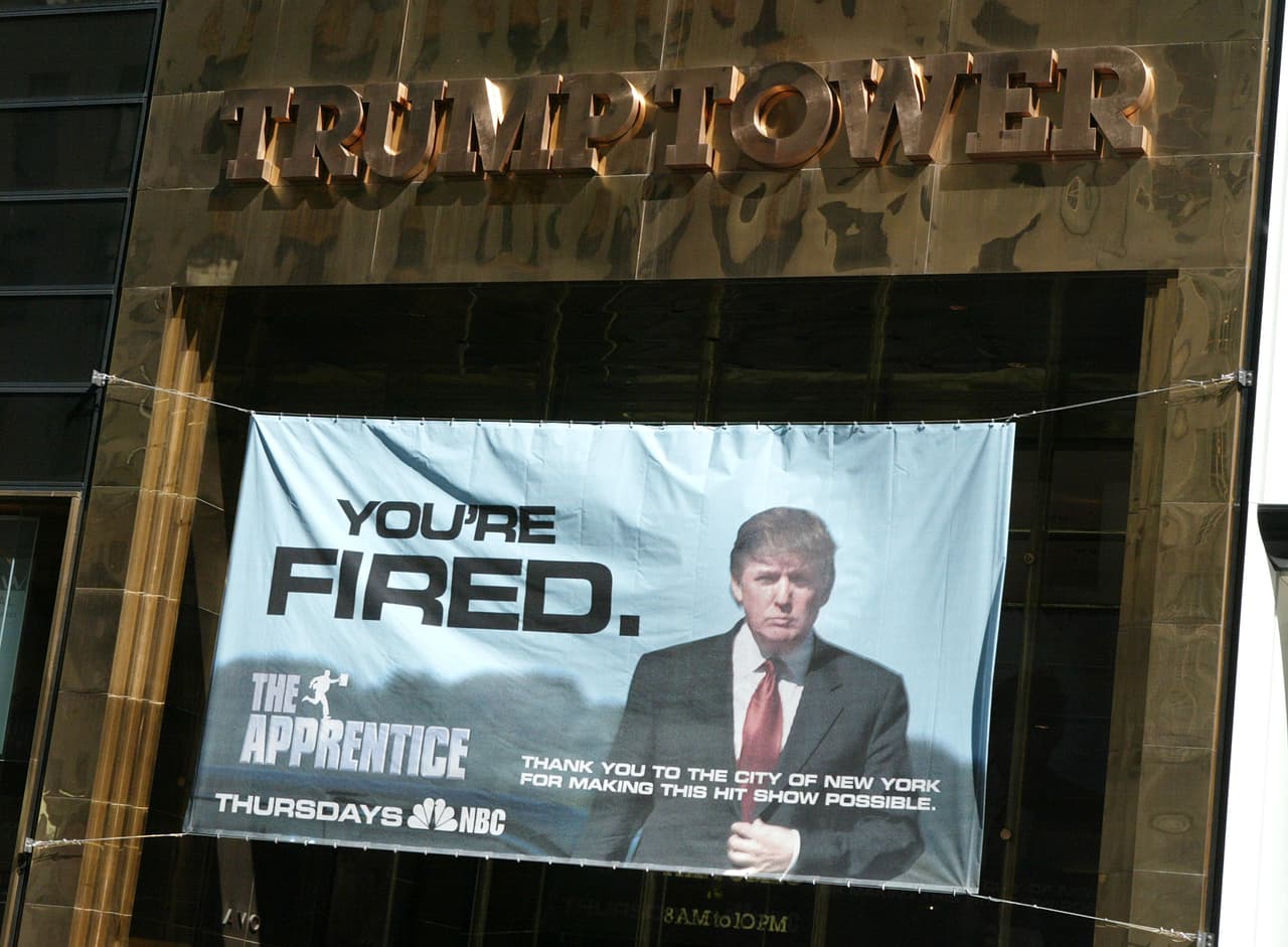 En esta fotografía fue tomada en 2004, en la torre Trump de Nueva York. Muestra un afiche del programa de televisión The Apprentice, con la clásica expresión de Donald Trump, que algunos comparan con la que muestra en la fotografía del 27 de octubre en la sala situacional.