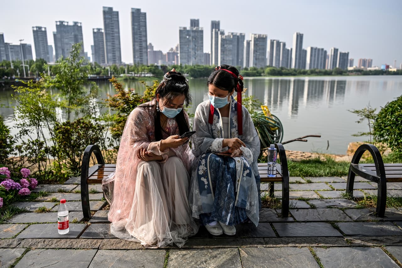 Dos mujeres con vestidos tradicionales y mascarillas en el Lago Este de Wuhan, el 17 de mayo. “Tuve suerte, nunca contraje el virus, lo demuestran la decena de pruebas que me he realizado desde entonces”, dijo el fotógrafo.