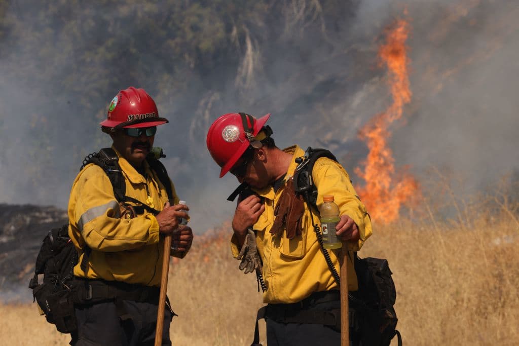 Fuertes vientos y temperaturas sobre los 100 Fahrenheit (38 C) afectaban este miércoles a los bomberos, que tomaban precacuciones mientras continuaban buscando frenar el avance los incendios.