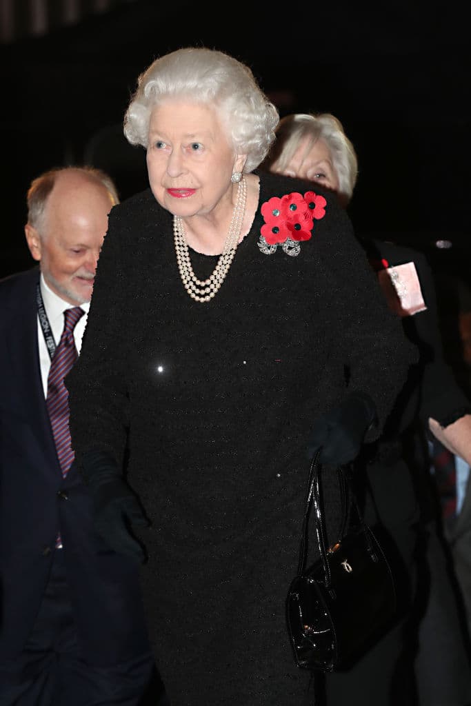 La reina Isabel II llegó vestida de negro, luciendo un collar de perlas. Como prendedor llevaba un pequeño racimo de amapola que resaltaba.
<br>