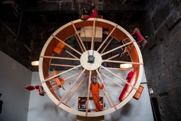 Hay veces que la monotonía de la vida se siente como una rueda de hámster gigante. De eso se trata el último performance de los artistas Ward Shelley y Alex Schweder de Brooklyn, quienes crearon una rueda de hámster de tres pisos en la que tendrán que coordinar cada movimiento durante 10 días. El performance llamado "En "rbita", está ubicado en una antigua sala de calderas en Williamsburg. Durante el performance, Schweder y Shelley van a comer, dormir, trabajar, ir al baño, etc, sin bajar de la rueda.