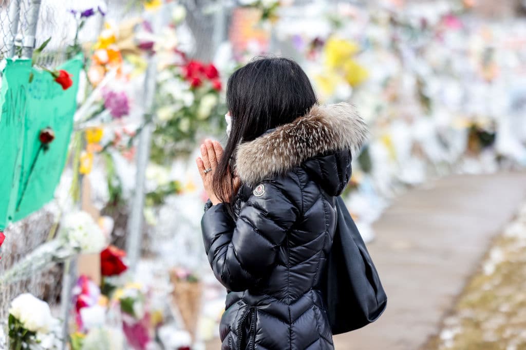 Takoua Debeche prays at a makeshift memorial for the victims of a mass shooting outside a King Soopers grocery store on March 24, 2021 in Boulder, Colorado.