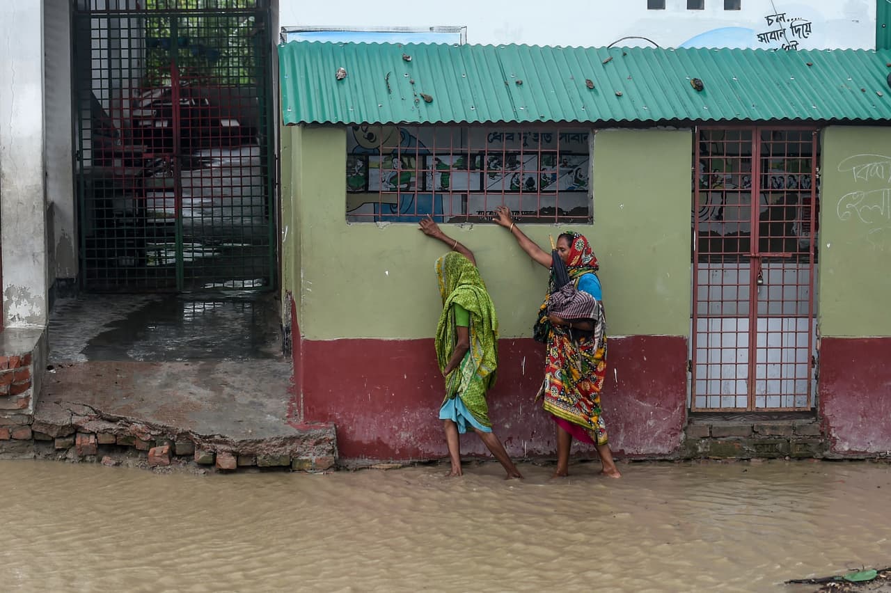 Residentes de Dacope, Bangladesh caminan por una calle inundada. Las autoridades temen que el ciclón Amphan sea más devastador que Sidr en 2007, que provocó 3,500 muertes.