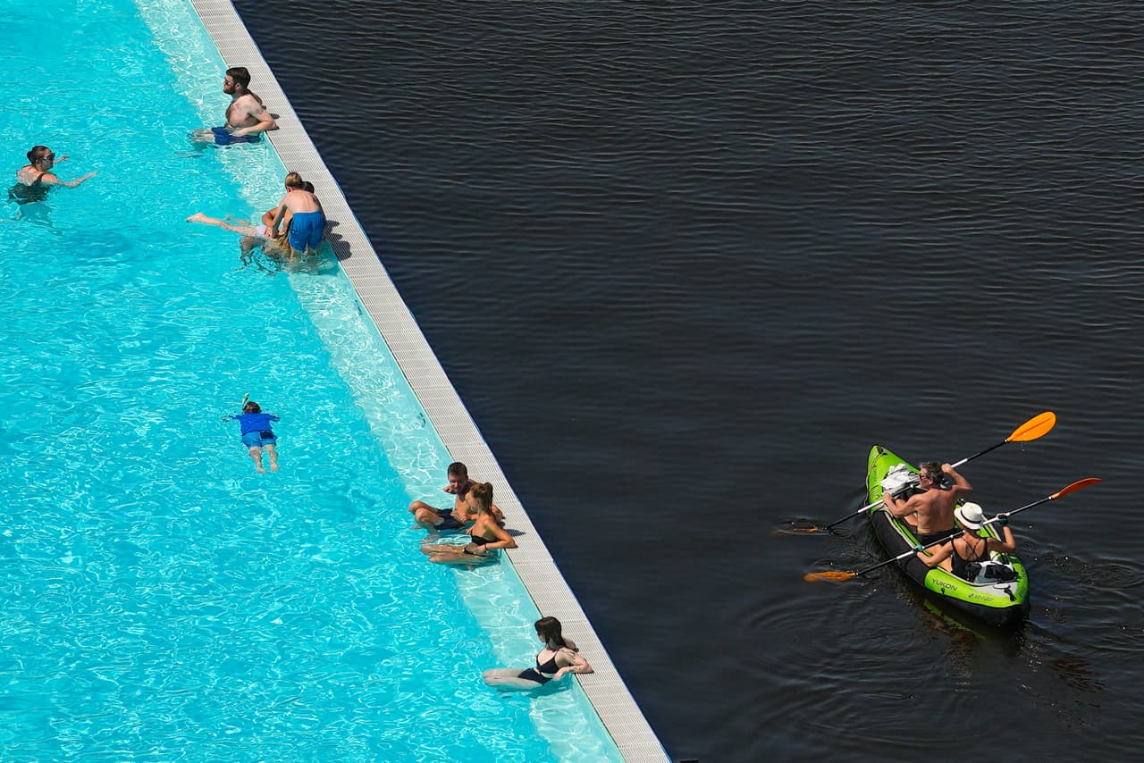 Un grupo de personas sobre una barca en el río Spree al lado de la piscina Badeschiff en Berlín, Alemania, donde se han registrado temperaturas sobre los 38º C (100.4º F).