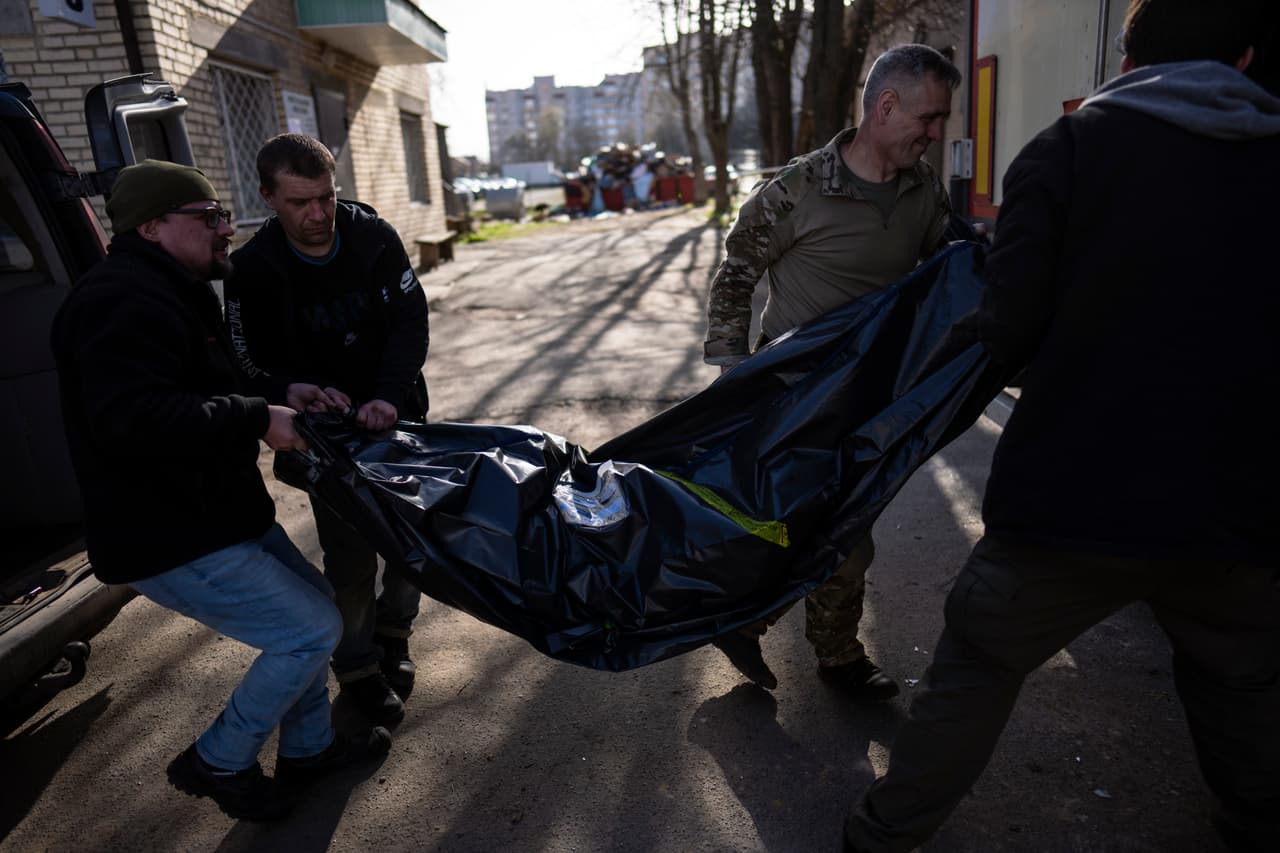 Voluntarios llevan el jueves 14 de abril de 2022 el cuerpo de un hombre que falleció a causa de los ataques rusos en Bucha, Ucrania. (AP Foto/Rodrigo Abd)