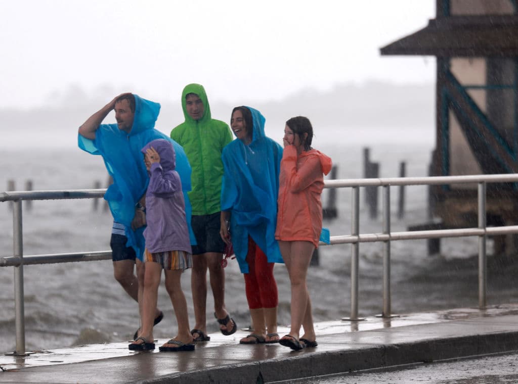 La gente camina a través de los vientos y la lluvia levantada por la tormenta tropical Debby, que se fortalece a medida que avanza a través del Golfo de México el 04 de agosto 2024 en Cedar Key, Florida.