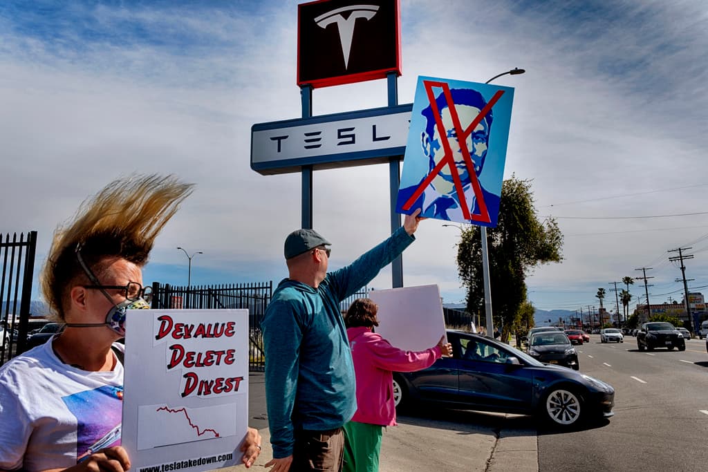 Manifestantes con pancartas y cantando consignas se encuentran afuera de un showroom y centro de servicio de Tesla en la sección de North Hollywood en Los Ángeles, el sábado 15 de marzo de 2025. (AP Foto/Richard Vogel)