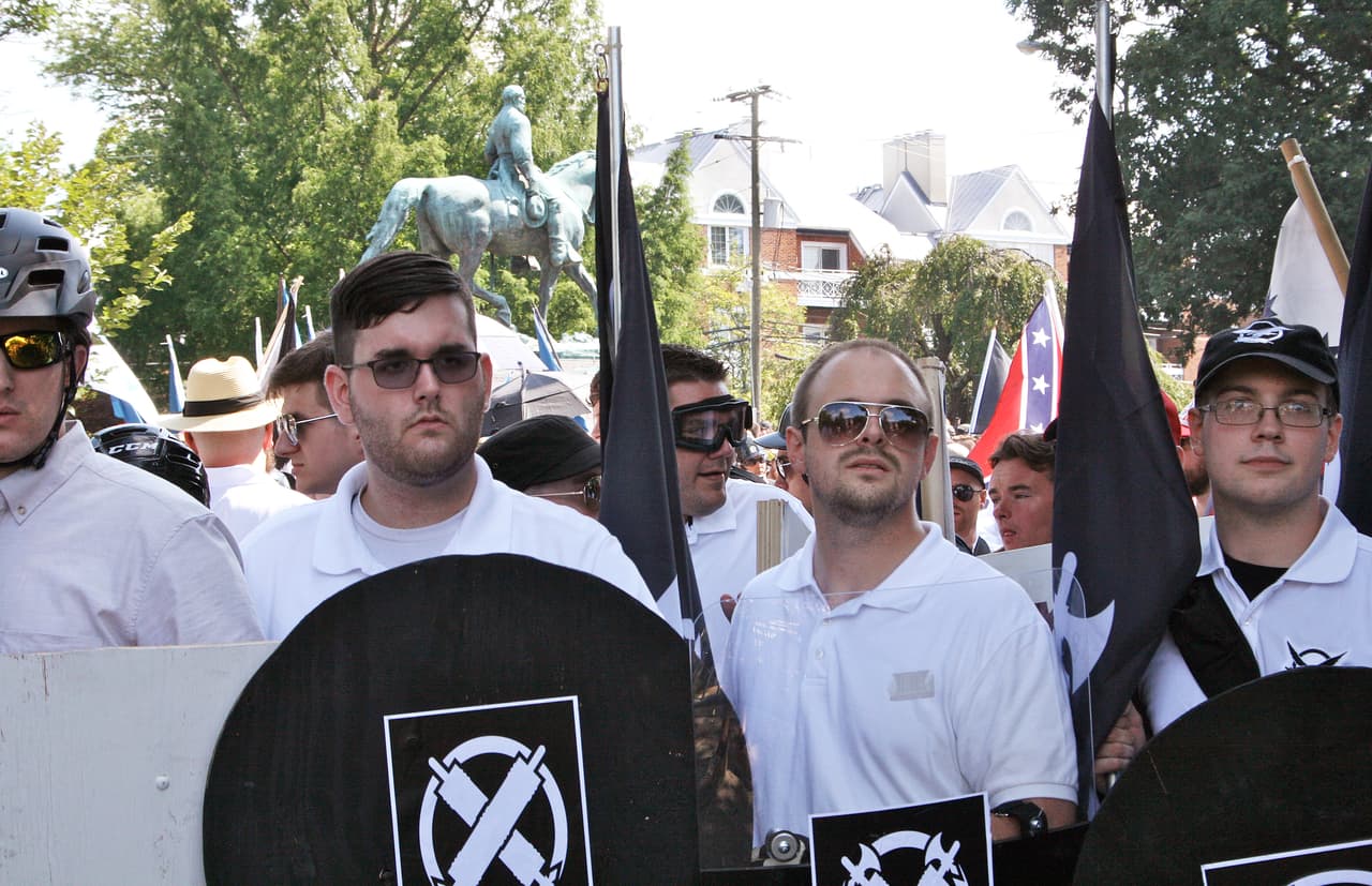 In this Saturday, Aug. 12, 2017 photo, James Alex Fields Jr., second from left, holds a black shield in Charlottesville, Va., where a white supremacist rally took place. Fields was later charged with second-degree murder and other counts after authorities say he plowed a car into a crowd of people protesting the white nationalist rally. (Alan Goffinski AP)