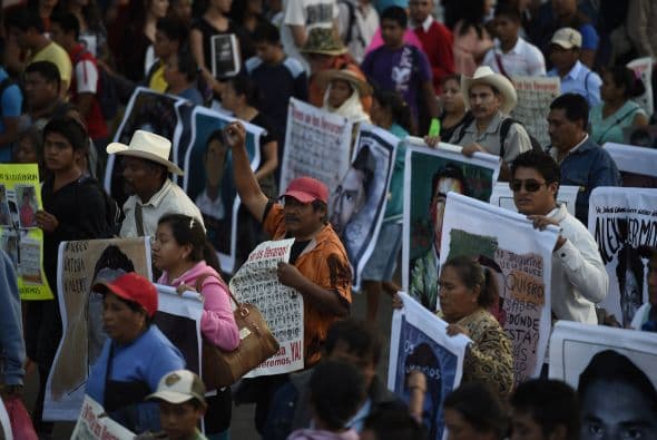 Los padres de los estudiantes asistieron a la marcha portando las fotografías de sus hijos.