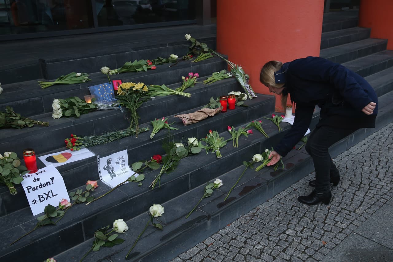 Una joven deposita flores en las escalinatas de la embajada de Bélgica en Berlín, Alemania.