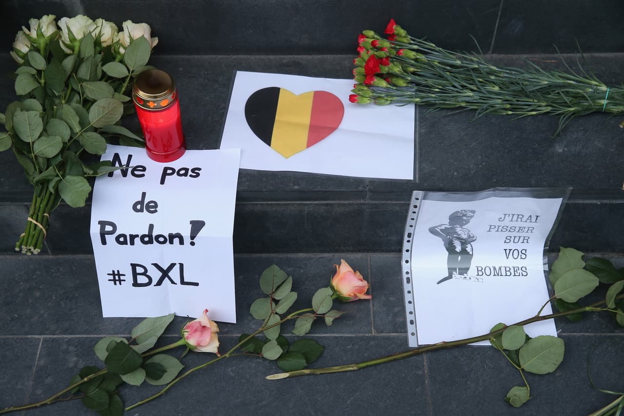 Entre los presentes dejados por los asistentes a la vigilia está un corazón iluminado con los colores de la bandera de Bélgica. También un mensaje que dice "No hay perdón".
