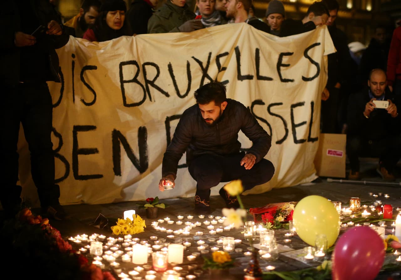 Un grupo de personas sostiene una pancarta de tela en señal de solidaridad con las víctimas del atentado.