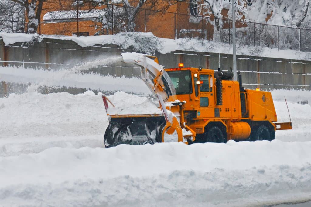 Un tractor remueve la nieve acumulada sobre una calle en Buffalo.