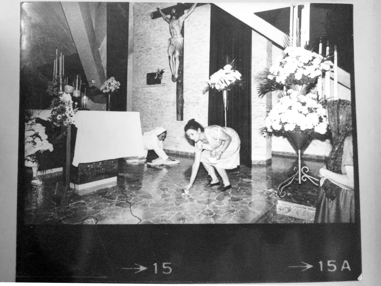 Dos mujeres –una monja, una de ellas– limpian la sangre del púlpito tras el asesinato de monseñor Romero.