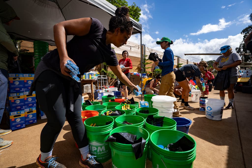 Voluntarios clasifican los suministros donados para su distribución en la destilería Haleiwa tras las recientes inundaciones, el martes 24 de marzo de 2026, en Waialua, Hawaii.