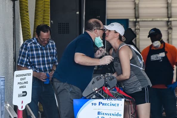 Mientras otros no fueron a votar por temor a contagiarse o lo hicieron con protección de máscaras y guantes, otros obviaron las recomendaciones de las autoridades sanitarias de limitar el roce social. Como estas dos personas que aprovecharon para saludarse con un beso al encontrarse en un centro de votación en Miami, Florida.