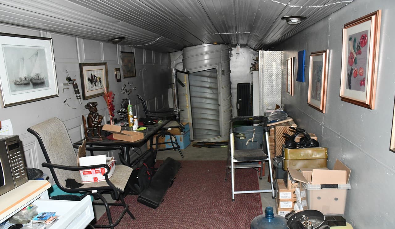 La orden se refería a una investigación de APS que abarcó más de un año, en la que se sospechaba que los propietarios del lugar suministraban a su negocio energía robada de una caja de conexiones de APS cercana. Los propietarios, Laura Swink, de 61 años, y su hijo, Steven Swink II, de 35 años, fueron detenidos por delitos graves de robo de servicios, daños criminales y obtención de servicios públicos de manera fraudulenta. Durante el servicio de la orden, se descubrió un gran búnker subterráneo en la propiedad. El búnker constaba de varias cajas conectadas y semirremolques apiladas juntas para construir un edificio de tres niveles equipado con elevadores de tijera y sistemas de escalera de túnel.