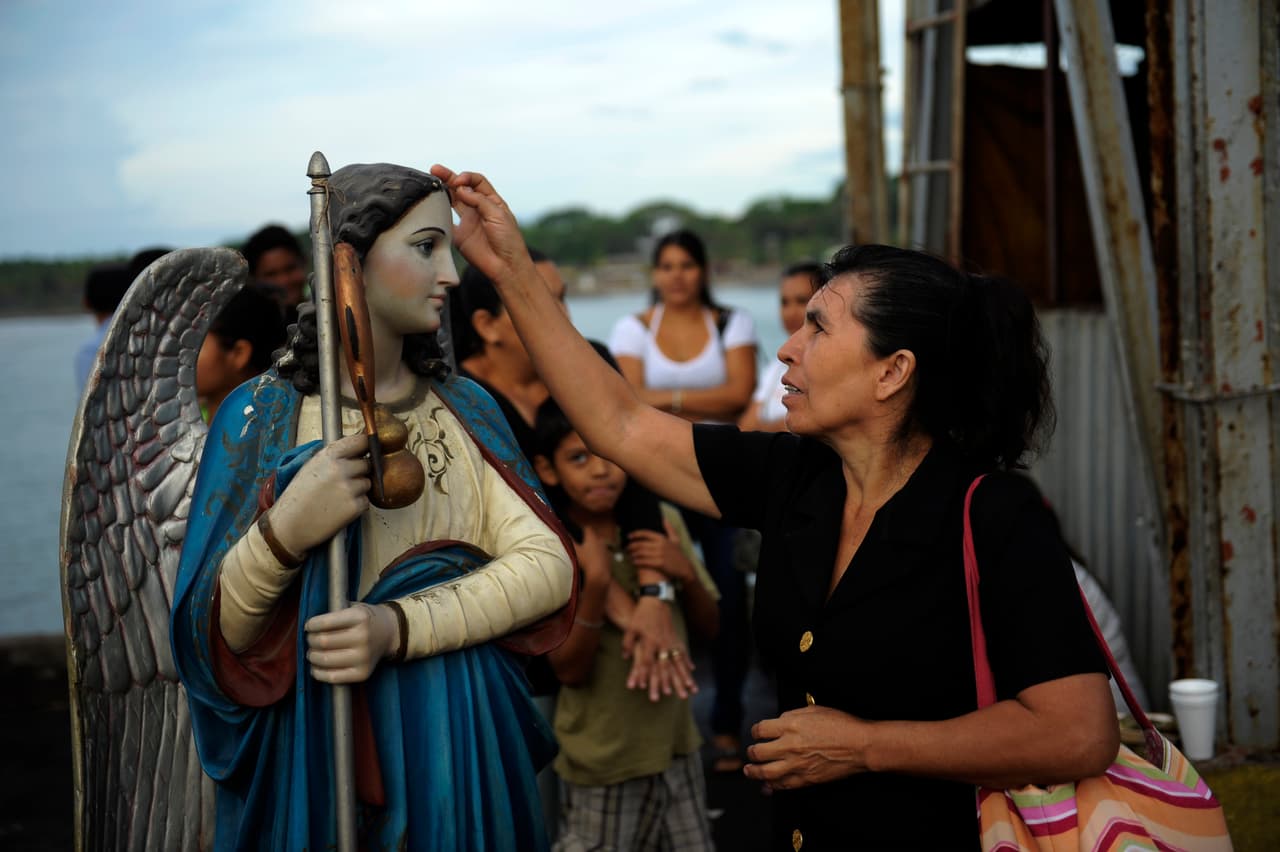 Este bastón o cayado que lleva en algunas representaciones simboliza la voluntad y el apoyo espiritual necesarios para recorrer el camino de la vida. También representa la autoridad espiritual que desvía y transforma las influencias negativas que nos rodean en algo más positivo y tranquilizador.