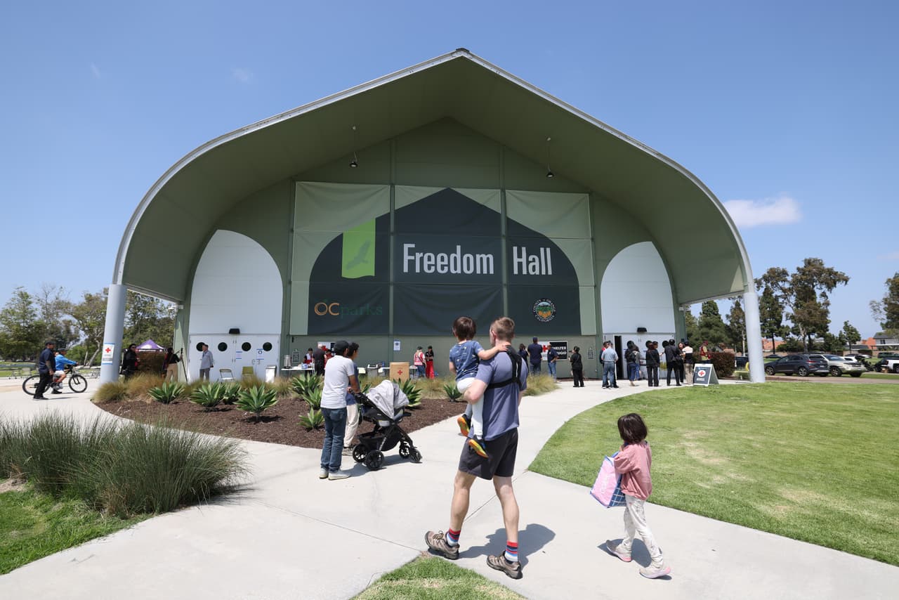 Varias personas llegan a Freedom Hall, un centro de evacuación en Fountain Valley, California, después de que un tanque de almacenamiento que contenía un producto químico utilizado para fabricar piezas de plástico se sobrecalentara el jueves en una planta de plásticos aeroespaciales en Garden Grove, el sábado 23 de mayo de 2026. (Foto AP/Jill Connelly)