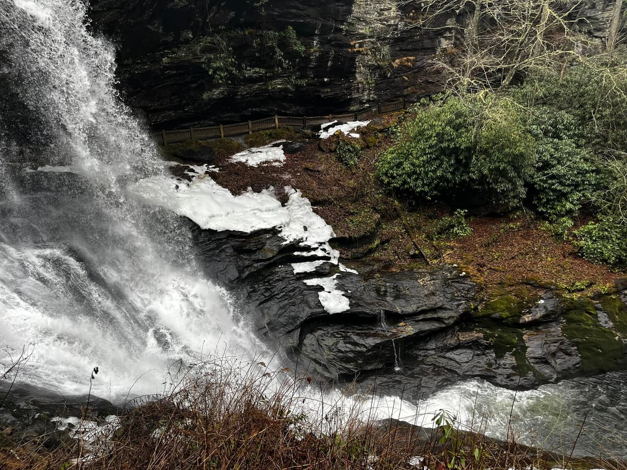 Las cascadas altas de 75 pies en el Bosque Nacional Nantahala fluyen sobre un acantilado, lo que permite caminar detrás de las cataratas y mantenerse seco (de ahí el nombre).
