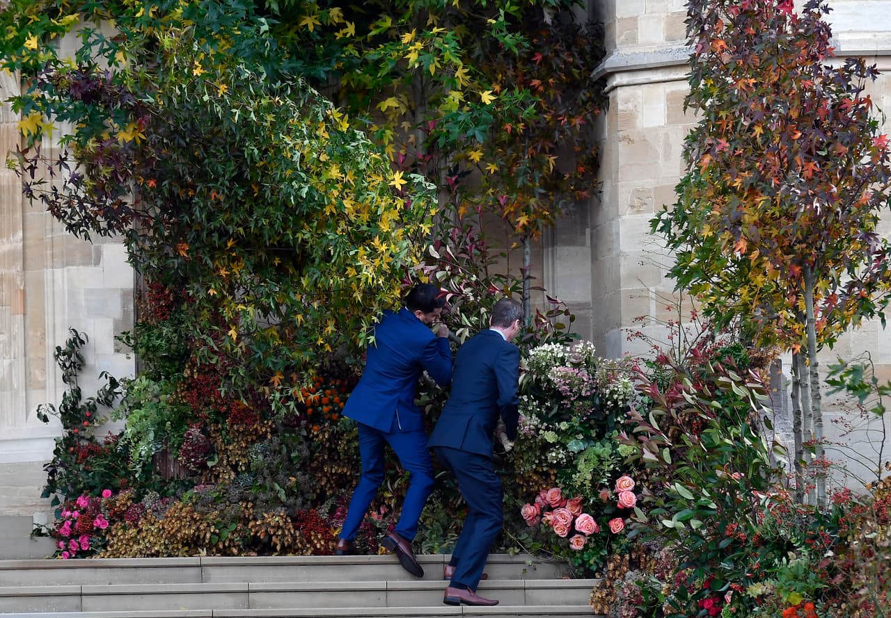 El viento era tan fuerte que algunos asistentes tuvieron que arreglar las flores de adorno que se habían puesto en el exterior de la capilla.
