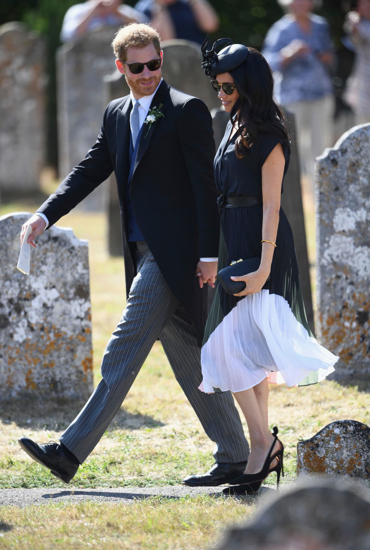 <b>4 de agosto 2018. Boda de verano del mejor amigo de Harry.</b>
<br>En el día de su cumpleaños, Meghan asisitó a la boda de Charlie van Straubenzee con la cineasta Daisy Jenksa. Para el evento eligió un vestido azul marino de 
<b>Club Mónaco</b> ($328) con falda tableada y estampado gráfico. Lo combinó con un cinturón atado negro de 
<b><a href="http://meghansmirror.com/product/miu-miu-knot-tied-belt/">Miu Miu</a></b>, tacones negros 
<b><a href="https://www.aquazzura.com/en/boutique-online/woman/view-all.html?gclid=CjwKCAjwhqXbBRAREiwAucoo-wuIo3Au1t52dRj1UVQrGlBFRmJPK4IWXb4JVdxegydbdOVql5LtBRoCCKIQAvD_BwE">Aquazzura</a></b> ($750) y clutch de la firma 
<a href="https://kayudesign.com/">Kayu</a>. 
<br>