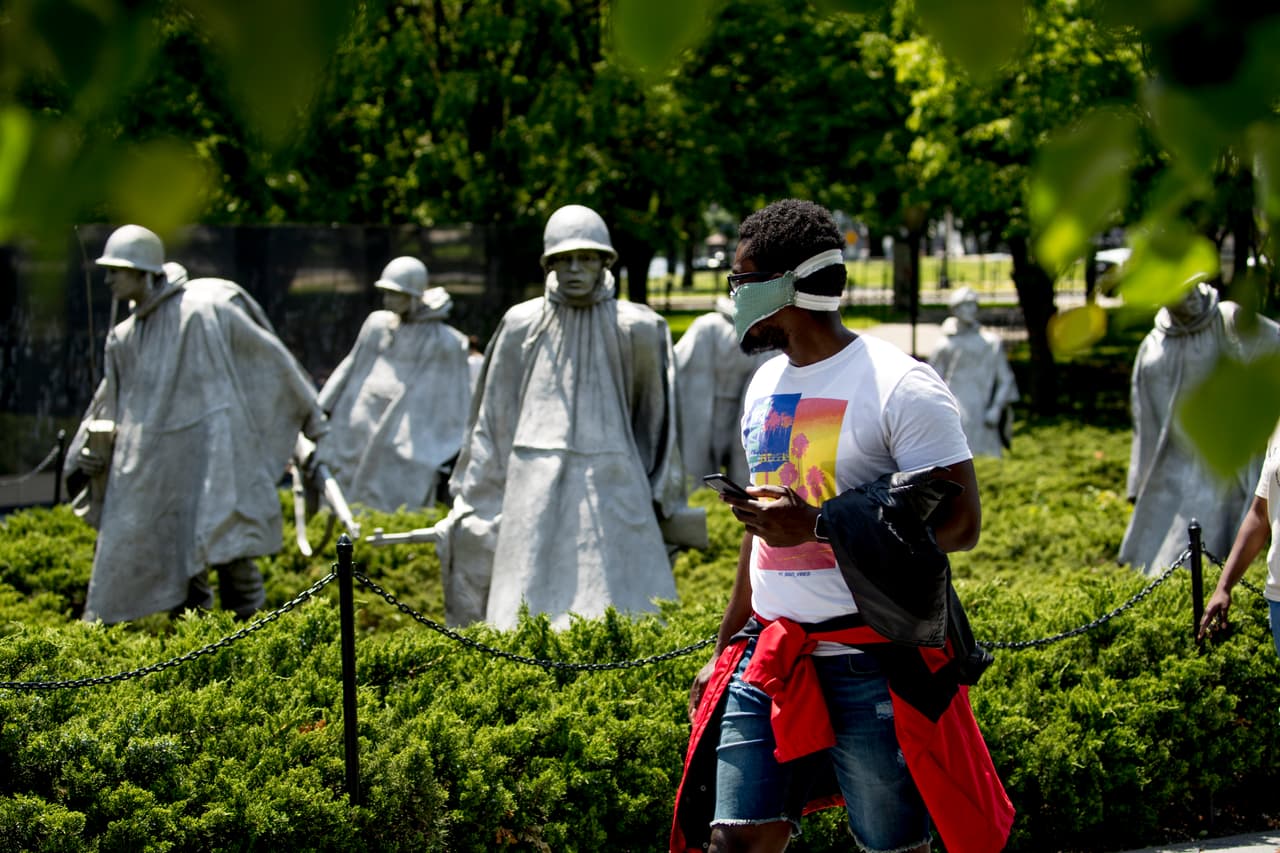 Un hombre usa una máscara mientras visita el Memorial de los Veteranos de la Guerra de Corea en el National Mall el Día de los Caídos en Washington.
